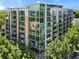 Exterior view of a modern condo building surrounded by lush trees at 905 Juniper Ne St # 808, Atlanta, GA 30309