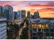 Condo view of the city skyline at dusk with floor to ceiling windows and mature trees at 905 Juniper Ne St # 808, Atlanta, GA 30309