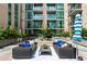 Stylish outdoor patio lounge area with comfortable seating, landscaping, and modern building facade at 905 Juniper Ne St # 808, Atlanta, GA 30309