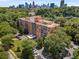 Aerial view of building surrounded by mature trees and Atlanta skyline in distance at 130 26Th Nw St # 415, Atlanta, GA 30309