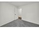 Bright, empty bedroom with grey carpets and a white door leading to another room at 1645 Cobbs Creek Ln, Decatur, GA 30032