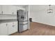 Open-concept kitchen with stainless steel fridge, granite counters, white cabinets, and fireplace in the distance at 1645 Cobbs Creek Ln, Decatur, GA 30032
