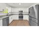 Modern kitchen with white cabinets, granite countertops, stainless steel appliances, and a view to the backyard at 1645 Cobbs Creek Ln, Decatur, GA 30032