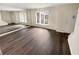 Spacious living room with hardwood floors, large windows, and a mirrored wall feature at 1805 Ashborough Se Cir # H, Marietta, GA 30067