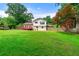 Large backyard with lush lawn, privacy fence, mature trees, and a charming outdoor deck at 273 Hardwood Ln, Lawrenceville, GA 30044