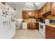 Kitchen with white appliances, wood cabinets and tile floors at 273 Hardwood Ln, Lawrenceville, GA 30044