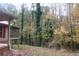View of backyard showing a brick patio with wooded views and a screened in porch at 618 Old Doss Dr, Canton, GA 30115