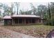 Charming home with a red metal roof, a welcoming front porch, and well-established landscaping at 618 Old Doss Dr, Canton, GA 30115