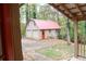 View of garage with a red door and grey siding amongst trees at 618 Old Doss Dr, Canton, GA 30115