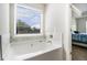 Modern white bathtub with a window view and marble backsplash at 741 Jackson Ct, Social Circle, GA 30025