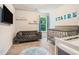 Stylish Bedroom with gray sofa, modern crib, and letter rug at 741 Jackson Ct, Social Circle, GA 30025