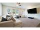 Spacious living room featuring plush carpet, a large sectional sofa, and bright natural light at 741 Jackson Ct, Social Circle, GA 30025