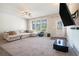 Bright and airy living room with a cozy sectional sofa, large windows, and a ceiling fan for comfortable living at 741 Jackson Ct, Social Circle, GA 30025