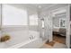 Bright bathroom featuring a bathtub and separate glass shower, with a view into the bedroom at 2003 Haley Walk, Woodstock, GA 30188