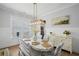 Sunlit dining area with stylish decor, including a modern chandelier and elegant seating at 2003 Haley Walk, Woodstock, GA 30188