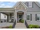 Inviting entrance with stone archway and a well-lit porch, enhancing curb appeal and accessibility at 2003 Haley Walk, Woodstock, GA 30188