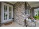 Inviting front porch with stone accents, double doors, and comfortable seating area at 2003 Haley Walk, Woodstock, GA 30188
