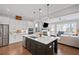 Bright open kitchen featuring a large center island, stainless steel appliances, and a view into the living area at 2003 Haley Walk, Woodstock, GA 30188