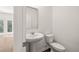 Powder room with pedestal sink and modern toilet, adjacent to a room with exterior access at 45 Vermillion Trl, Covington, GA 30016