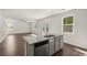 Open kitchen with stainless dishwasher, granite island sink, and ample natural light at 45 Vermillion Trl, Covington, GA 30016