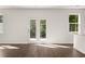 Living area with wood floors, large windows, and French doors to the exterior at 45 Vermillion Trl, Covington, GA 30016