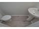 Well-lit half bathroom featuring modern fixtures, including a pedestal sink and toilet at 48 Beaver Pt, Villa Rica, GA 30180