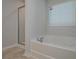 Bright bathroom showcasing a soaking tub beneath a window with natural light at 48 Beaver Pt, Villa Rica, GA 30180