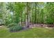 A serene backyard featuring mature trees, lush greenery, and a landscaped lawn at 6009 Castleton Mnr, Cumming, GA 30041