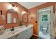 Stylish bathroom with double sinks, an accent wall, and an adjoining toilet room at 6009 Castleton Mnr, Cumming, GA 30041