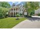 Charming two-story brick home featuring a spacious front lawn and a welcoming covered porch with columns at 6009 Castleton Mnr, Cumming, GA 30041