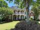Charming two-story brick home with a welcoming front porch and beautifully landscaped yard at 6009 Castleton Mnr, Cumming, GA 30041