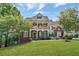 Charming two-story brick home featuring a spacious front lawn and a welcoming covered porch with columns at 6009 Castleton Mnr, Cumming, GA 30041