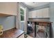 Convenient laundry room featuring modern washer and dryer, storage cabinets, and a functional folding counter at 6009 Castleton Mnr, Cumming, GA 30041