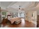 Spacious main bedroom with hardwood floors, a tray ceiling, and an en-suite bathroom at 6009 Castleton Mnr, Cumming, GA 30041