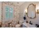 Charming powder room featuring floral wallpaper, a decorative mirror, and a marble countertop sink at 6009 Castleton Mnr, Cumming, GA 30041