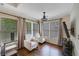 Cozy sitting area featuring hardwood floors, neutral armchairs, and natural light from large windows at 6009 Castleton Mnr, Cumming, GA 30041