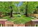 Large backyard featuring two chairs, lush green grass, mature trees, and a storage shed at 34 Clifton Se St, Atlanta, GA 30317