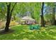 Spacious backyard with a deck, mature trees, lush green lawn, and comfortable seating area at 34 Clifton Se St, Atlanta, GA 30317