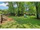 Expansive backyard with a wooden deck, mature trees, lush green grass, and a fire pit area with Adirondack chairs at 34 Clifton Se St, Atlanta, GA 30317