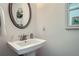 Powder room with pedestal sink, round mirror, and wainscoting at 351 Gaines St, Marietta, GA 30060