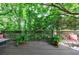 Outdoor deck with potted plants, chair, and views of the mature trees in the backyard at 4470 Crestwicke Pointe, Atlanta, GA 30319