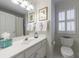 Clean, bright bathroom with a white vanity, a large mirror, and a toilet next to a window with plantation shutters at 4470 Crestwicke Pointe, Atlanta, GA 30319