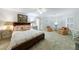 Inviting primary bedroom with plush carpet, complemented by floral armchairs and natural light from shuttered windows at 4470 Crestwicke Pointe, Atlanta, GA 30319