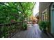 Charming outdoor deck featuring potted plants, a small seating area, and a wooden railing overlooking a lush backyard at 4470 Crestwicke Pointe, Atlanta, GA 30319