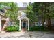 Charming brick home featuring a covered front entrance, mature trees, and a well-manicured landscaped yard at 4470 Crestwicke Pointe, Atlanta, GA 30319