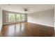 Bright bedroom featuring hardwood floors, white trim, a ceiling fan, and natural light from shuttered windows at 22 Mount Paran Rd, Atlanta, GA 30327