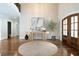 Bright foyer features hardwood floors, a decorative table, an olive tree, and a curved staircase at 22 Mount Paran Rd, Atlanta, GA 30327