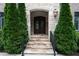 Stone entrance with double wood doors, black iron handrails, exterior lantern, and manicured shrubbery at 22 Mount Paran Rd, Atlanta, GA 30327