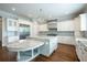 Kitchen with custom island, stainless steel vent hood, and white cabinets at 22 Mount Paran Rd, Atlanta, GA 30327