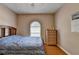 Comfortable bedroom with hardwood floors, arched window, dresser, and neutral paint at 2694 Sterling Dr, Lawrenceville, GA 30043